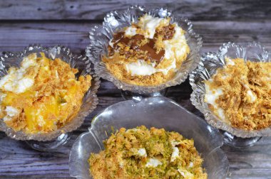 Mısır 'daki tatlı Koshary tarifi sütlü tatlı puding, çırpılmış krema, kavrulmuş Konafa ve phyllo filo, şam fıstığı soslu, çikolata ezmeli, bisküvi kremalı ve mangolu.