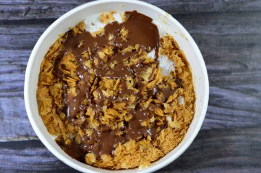 Mısır 'daki tatlı Koshary tarifinin üstüne sütlü puding, krem şanti, kızarmış Konafa ve filo ile birlikte diğer tatlar ve dolgulardan yapılmış çikolata ezmesi sosu.