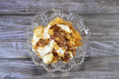 Mısır 'daki tatlı Koshary tarifinin üstüne sütlü puding, krem şanti, kızarmış Konafa ve filo ile birlikte diğer tatlar ve dolgulardan yapılmış çikolata ezmesi sosu.