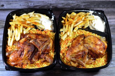 Arap mutfağından ızgara ızgara tavuk rengarenk Basmati pilavı ve patates kızartması sarımsak sosuyla servis edilen siyah bir tek kullanımlık tabakta servis ediliyor.