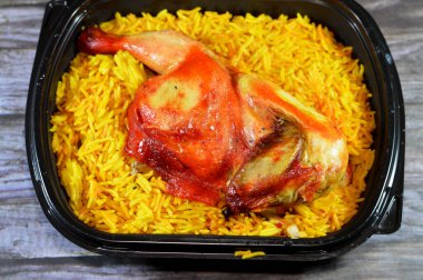 Genellikle domates sosu, yeşil salata ve tahini ile servis edilen uzun basmati pilavlı tavuk mandi kabsa, Yemen usulü baharatlı ve soslu tavuk ve pilav, seçici odaklı