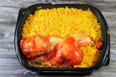 Genellikle domates sosu, yeşil salata ve tahini ile servis edilen uzun basmati pilavlı tavuk mandi kabsa, Yemen usulü baharatlı ve soslu tavuk ve pilav, seçici odaklı