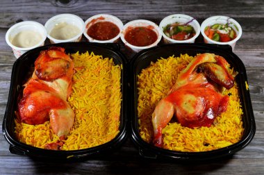 Kahire, Mısır, 26 Aralık 2023: Hadramout Antar restoranı Tavuk mandi kabsa ve uzun basmati pilavı, domates sosu, yeşil salata ve tahini, Mandi tavuğunun Yemen tarifi