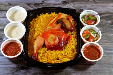 Kahire, Mısır, 26 Aralık 2023: Hadramout Antar restoranı Tavuk mandi kabsa ve uzun basmati pilavı, domates sosu, yeşil salata ve tahini, Mandi tavuğunun Yemen tarifi