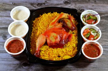 Kahire, Mısır, 26 Aralık 2023: Hadramout Antar restoranı Tavuk mandi kabsa ve uzun basmati pilavı, domates sosu, yeşil salata ve tahini, Mandi tavuğunun Yemen tarifi
