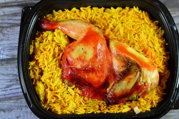 Chicken mandi kabsa with long basmati rice, usually served with tomato dakos sauce, green salad and tahini, Yemen recipe of Yemeni Mandi chicken and rice with spices and sauce, selective focus