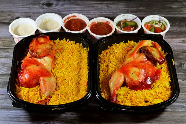 Kahire, Mısır, 26 Aralık 2023: Hadramout Antar restoranı Tavuk mandi kabsa ve uzun basmati pilavı, domates sosu, yeşil salata ve tahini, Mandi tavuğunun Yemen tarifi