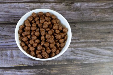 Çikolata aromalı kahvaltı gevrekleri. Çocuklar ve yetişkinler için sütle hazırlanmış atıştırmalık olarak. Çıtır çıtır çikolata aromalı toplar.