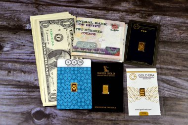 Kahire, Mısır, 2 Ocak 2024: 200 EGP Mısır sterlini katlandı. 200 Pound para banknotları ve Amerikan doları, ABD doları, SAM, BTC, İsviçre altını, 24 Karate dönemi saf sarı altın külçeler, yatırım, döviz kuru