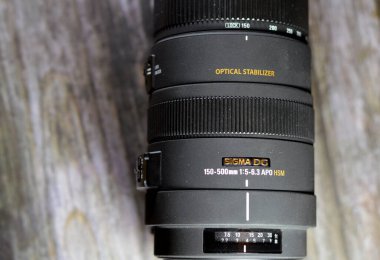 Kahire, Mısır, 6 Ocak 2024: Sigma APO 150-500mm F5-6.3 DG OS HSM lensi, Sigma Corporation tarafından üretilen bir süper telefoto lensi, Nikon, Canon, Pentax için yapılmış üç adet SLD cam element içermektedir.