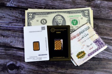Kahire, Mısır, 6 Ocak 2024: Mısır para pound 'u, Amerikan doları banknotları, BTC Bullion Ticaret Merkezi ve SAM değerli metal 24K karat saf sarı altın gram bar, altın yatırım