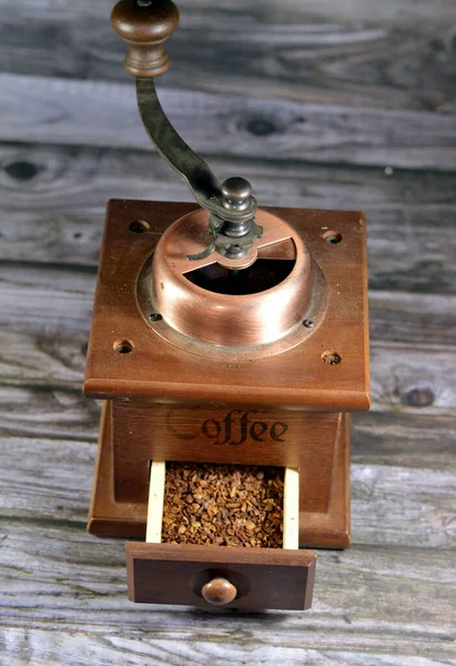 a manual coffee grinder burr mill machine with catch drawer, conical burr mill and spice hand grinding, an old style classic vintage retro coffee beans grinder with a wood drawer with coffee inside