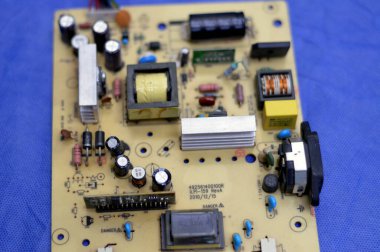 Kahire, Mısır, 13 Ocak 2024: LED TV televizyonunun ana güç devresi, kablolar, trafolar, direniş, IC ve kondansatörler, elektronik devreler içeren ana kartın onarımı