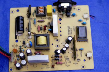 Kahire, Mısır, 13 Ocak 2024: LED TV televizyonunun ana güç devresi, kablolar, trafolar, direniş, IC ve kondansatörler, elektronik devreler içeren ana kartın onarımı