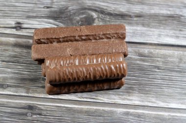 Karamel ve çikolatayla kaplı bisküvi, çikolatalı karamel, lezzetli fıstık ezmesi, tatlı karamel ve yumuşak sütlü çikolatayla kaplanmış kremalı bir merkez.