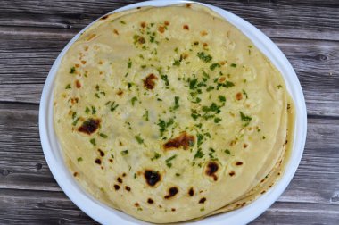 Hindistan ekmeği çok sıcak bir hamur tandır fırınında pişirildi. Lezzetli, yumuşak, kabarık, havadar. Yüzeyinde güzel altın kahverengi noktaları olan Hint ekmeği, sarımsak, tereyağı ve maydanozlu.