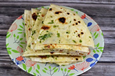 Hindistan ekmeği çok sıcak bir hamur tandır fırınında pişirildi. Lezzetli, yumuşak, kabarık, havadar. Yüzeyinde güzel altın kahverengi noktaları olan Hint ekmeği, sarımsak, tereyağı ve maydanozlu.