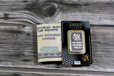 Kahire, Mısır, 25 Ocak 2024: Mısır Pound parası ve Akef saf gümüş Ounce 101.1 gram bar, gümüş yatırım, döviz kuru, enflasyon krizi ve para tasarrufu varlık kavramı