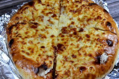 Çoklu katmanlı pizza keki, salam, barbekü tavuğu, peynir karışımı, sığır eti, sosis, mozarella peyniri, fırında pişirilmiş İtalyan pizzası, seçici odaklı bir pizza karışımı.