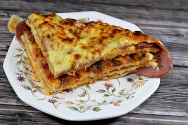 Çoklu katmanlı pizza keki, salam, barbekü tavuğu, peynir karışımı, sığır eti, sosis, mozarella peyniri, fırında pişirilmiş İtalyan pizzası, seçici odaklı bir pizza karışımı.