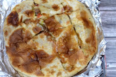 Fırında pişmiş ve parça parça dilimlenmiş Orta Doğu et sosisi, kıyma, domates, biber, şifalı otlar ve baharatlarla servis edilmeye hazır, seçici odaklanma