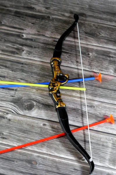 A plastic toy of a bow and arrows, Archery, The bow and arrow is a ranged weapon system consisting of an elastic launching device (bow) and long-shafted projectiles (arrows), kids\' tool