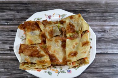 Fırında pişmiş ve parça parça dilimlenmiş Orta Doğu et sosisi, kıyma, domates, biber, şifalı otlar ve baharatlarla servis edilmeye hazır, seçici odaklanma