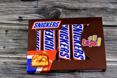 Kahire, Mısır, 4 Şubat 2024: Snickers, Amerikan markası Mars, Inc., ABD tarafından çikolatayla kaplanmış, üzerinde karamel ve fıstık bulunan bir çikolata markası.