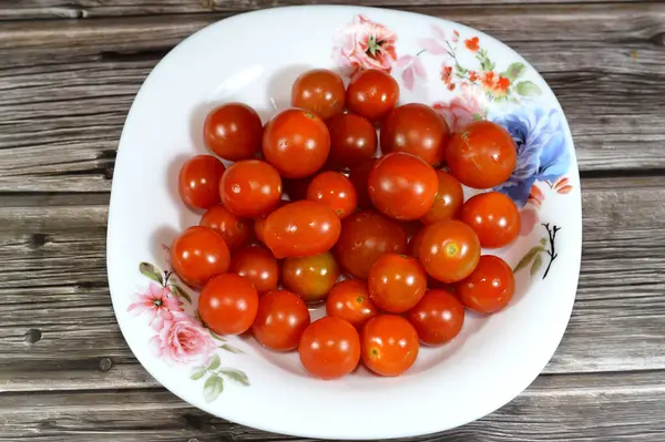 The cherry tomato, a type of small round tomato believed to be an intermediate genetic admixture between wild currant-type tomatoes and domesticated garden tomatoes, Cherry tomatoes range in size