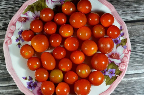 The cherry tomato, a type of small round tomato believed to be an intermediate genetic admixture between wild currant-type tomatoes and domesticated garden tomatoes, Cherry tomatoes range in size