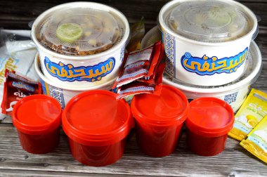 Kahire, Mısır, 5 Şubat 2024: Sayed Hanafy Koshary Koshari, pilav, makarna, spagetti ve mercimek karışımı baharatlı domates sosu, sarımsak sirkesi, kızarmış soğan, humus nohutu