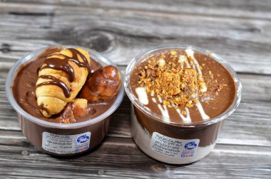 Kahire, Mısır, 5 Şubat 2024: Remas Land kremalı çikolatalı profiteroller, çikolata, sos, fıstık ezmesi, badem, kremalı puf, Fransız choux pasta toplarıyla doldurulmuş Molto kruvasanı