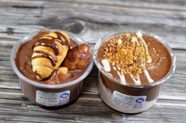 Kahire, Mısır, 5 Şubat 2024: Remas Land kremalı çikolatalı profiteroller, çikolata, sos, fıstık ezmesi, badem, kremalı puf, Fransız choux pasta toplarıyla doldurulmuş Molto kruvasanı