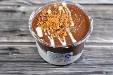 Kahire, Mısır, 5 Şubat 2024: Remas Land kahverengisi, tatlandırılmış fındıklı kakao kaplı profiterol, çikolata kremalı ve bademli profiteroller kremalı puf, Fransız choux pasta topu