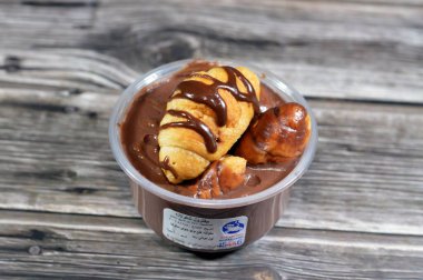 Kahire, Mısır, 5 Şubat 2024: Remas Land çikolatalı profiterolü, çikolata, sos, fıstık ezmesi, profiterol kremalı, Fransız choux pastry ball ile doldurulmuş.