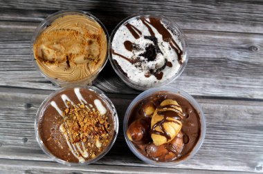 Çikolata, sos, fıstık ezmesi, badem ve çikolata soslu kremalı kremalı kremalı profiterolle doldurulmuş mini kruvasan, çikolatalı kek ve kahverengi bisküvi.