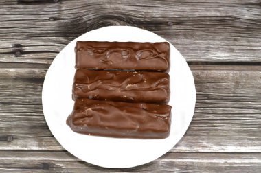 Çikolata, karamelli ve fıstıklı fındıklı, üstü sütlü çikolata, karamel ve çikolatayla kaplı, çikolata karamelli çikolata, lezzetli bir karışım, tatlı karamelli fıstık, tatlı karamel