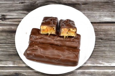 Çikolata, karamelli ve fıstıklı fındıklı, üstü sütlü çikolata, karamel ve çikolatayla kaplı, çikolata karamelli çikolata, lezzetli bir karışım, tatlı karamelli fıstık, tatlı karamel