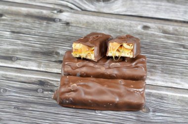 Çikolata, karamelli ve fıstıklı fındıklı, üstü sütlü çikolata, karamel ve çikolatayla kaplı, çikolata karamelli çikolata, lezzetli bir karışım, tatlı karamelli fıstık, tatlı karamel