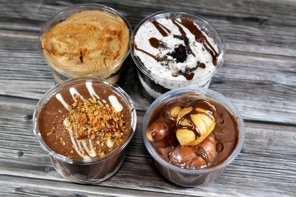 Çikolata, sos, fıstık ezmesi, badem ve çikolata soslu kremalı kremalı kremalı profiterolle doldurulmuş mini kruvasan, çikolatalı kek ve kahverengi bisküvi.