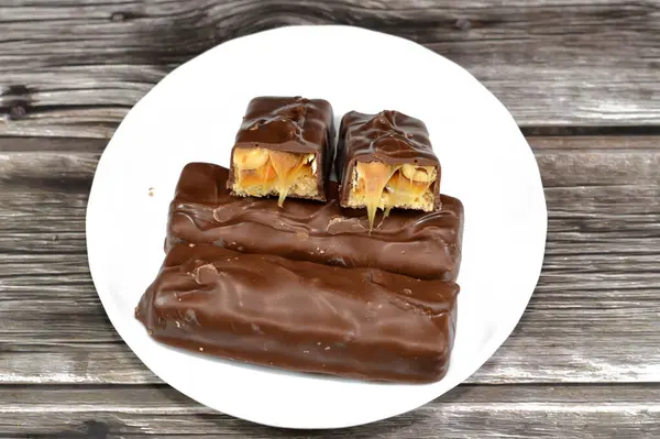 Çikolata, karamelli ve fıstıklı fındıklı, üstü sütlü çikolata, karamel ve çikolatayla kaplı, çikolata karamelli çikolata, lezzetli bir karışım, tatlı karamelli fıstık, tatlı karamel