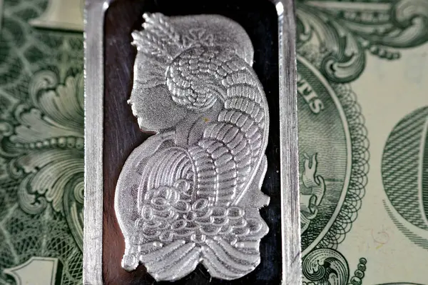 USD American dollars cash money and silver precious metal ounce bar of pure silver, The price of silver is driven by speculation, supply and demand and it\'s usually bought as an investment