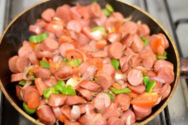 Sosis (Viyana sosisi) adı verilen ızgara sosisli sandviç ve sosis, domates, soğan ve yeşil biber dilimleri ile birlikte, sıcak suda kaynatıldıktan sonra yağda kızartılmış, seçici bir odaklanma.