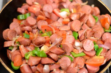 Sosis (Viyana sosisi) adı verilen ızgara sosisli sandviç ve sosis, domates, soğan ve yeşil biber dilimleri ile birlikte, sıcak suda kaynatıldıktan sonra yağda kızartılmış, seçici bir odaklanma.