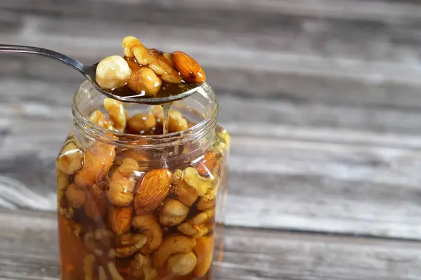 Honey with mixed nuts, walnuts, hazelnuts, almonds and cashews in natural honey, which is a sweet and viscous substance made by several bees, made and stored to nourish bee colonies, mixed nuts honey