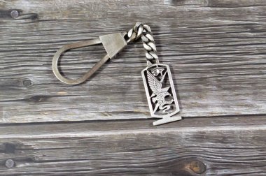 Bir kartal ya da şahin, üzerinde gümüş değerli bir metal anahtarlık madalyası, döviz kuru pazarlama ve değeri, ticaret, gümüş konseptin fiyatı, değerli bir mağaza olarak yatırım olan bir yılan yakalar.