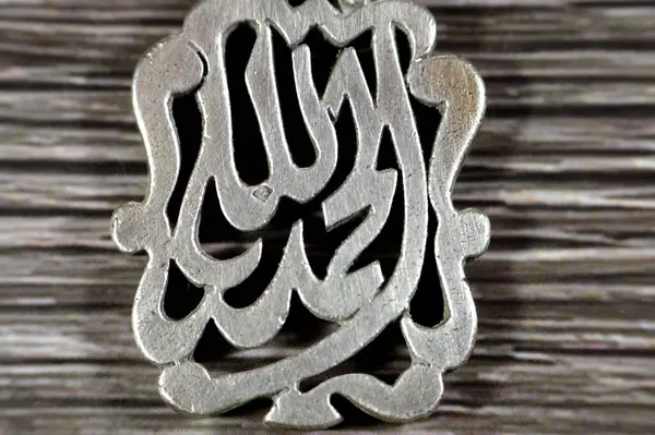 Arabic Text Translation (Thank God, Praise be to Allah) on silver precious metal keyring medal, exchange rate marketing and value, business, price of silver concept, an investment as a store of value