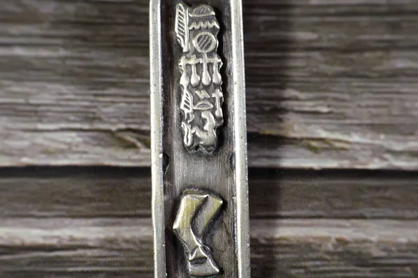 Pharaonic shapes and letters on a silver precious metal keyring medal, exchange rate marketing and value, business, price of silver concept, an investment as a store of value