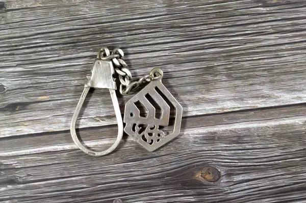 Translation of the Arabic Text (Allah, God) on a silver precious metal keyring medal, exchange rate marketing and value, business, price of silver concept, an investment as a store of value