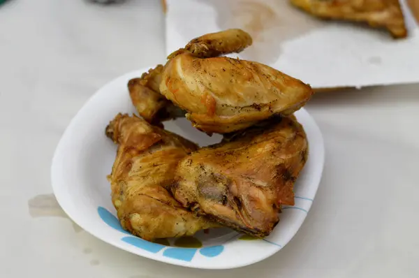 fried chicken quarters with skin and bones, baking, grilling, barbecuing, frying ready to be served, white meat of chicken quarters in a plate, selective focus